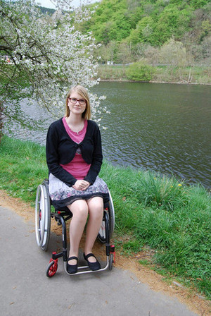 Nicole sitzt im Rollstuhl neben einen Fluss