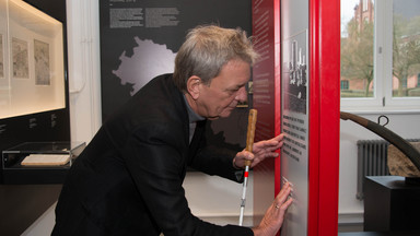 Ein Mann steht in der Zeche Zollern vor einer Infotafel mit Braille