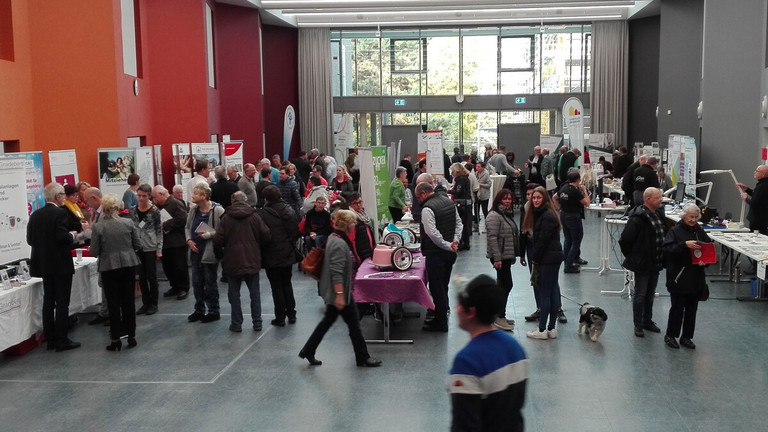 Bild vom Tag der Begegnung in Ennigerloh: Besucher und Besucherinnen informieren sich an den Ständen der Aussteller