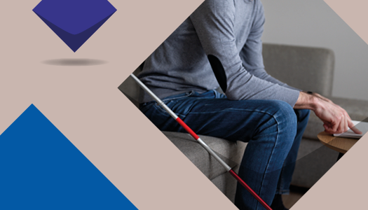 Eine blaue Kachel und ein Foto von einem Mensch auf dem Sofa. Im Vordergrund liegt ein Blindenstock