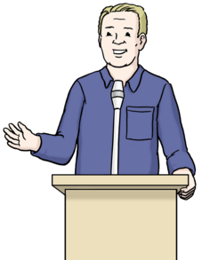 Auf dem Bild sieht man einen Mann mit heller Haut und blonden kurzen Haaren. Er trägt ein blaues Hemd. Der Mann steht vor einem Rednerpult und hält seine rechte Hand hoch.