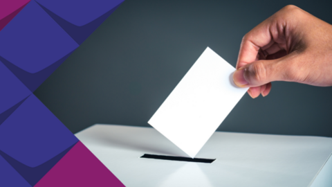 Bild von einer Hand, die einen Wahlzettel in die Wahlurne wirft