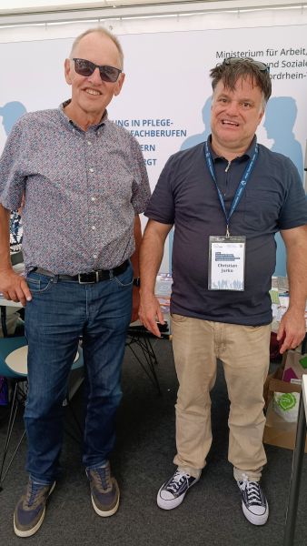 Wolfgang Bennewitz, ein lächelnder Mann mit kurzem Haar und Sonnenbrille steht neben Christian Jurko, ein lächelnder Mann mit dunklen Haaren