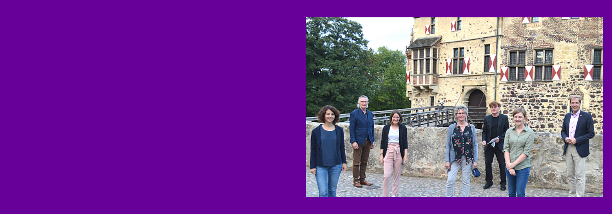 Das Veranstaltungsteam gemeinsam mit Landrat Dr. Christian Schulze-Pellengahr (rechts) und Sozialdeszernent des Kreises Detlef Schütt (links) auf dem Gelände der Burg Vischering in Lüdinghausen.