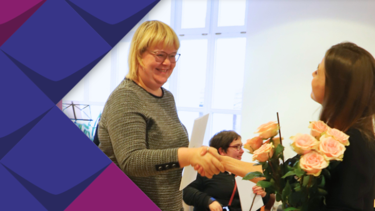 Eine Teilnehmende des Projekts HospInk erhält zum Abschluss einen Blumenstrauß.